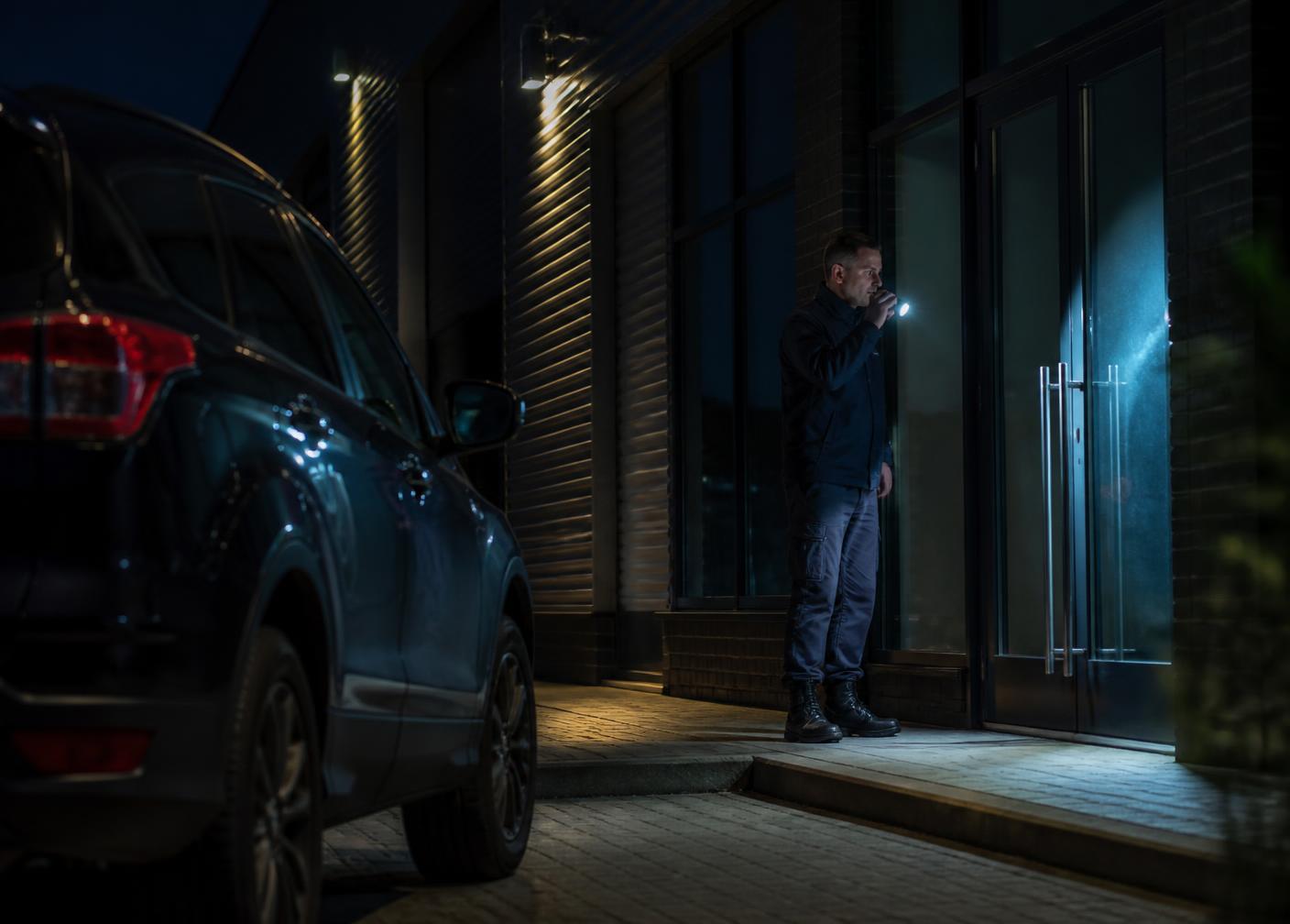 Security officer carrying out an alarm response check at commercial premises at night